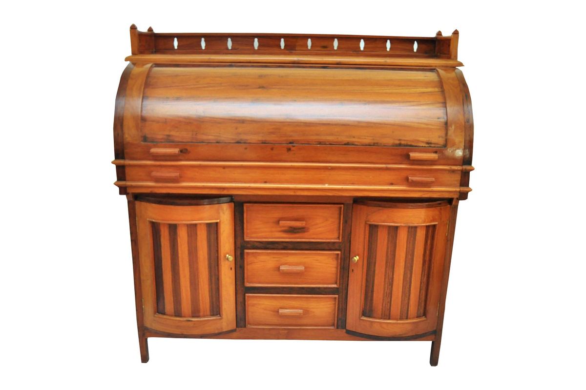 A cylinder desk in solid teak by Carpenters Choice — the roll closed, with a pierced gallery, three drawers, and two bow-fronted doors